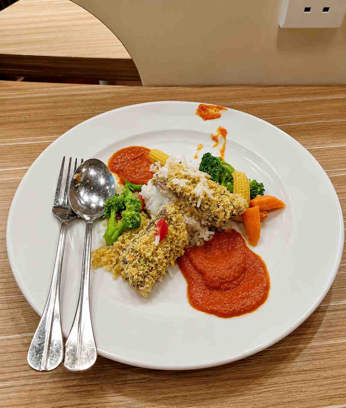 Plated meal with rice, vegetables and sauce served nearby